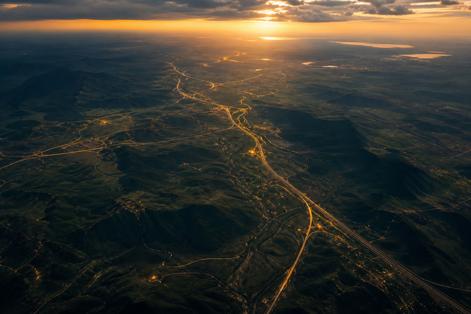 Aerial dusk over a development corridor landscape